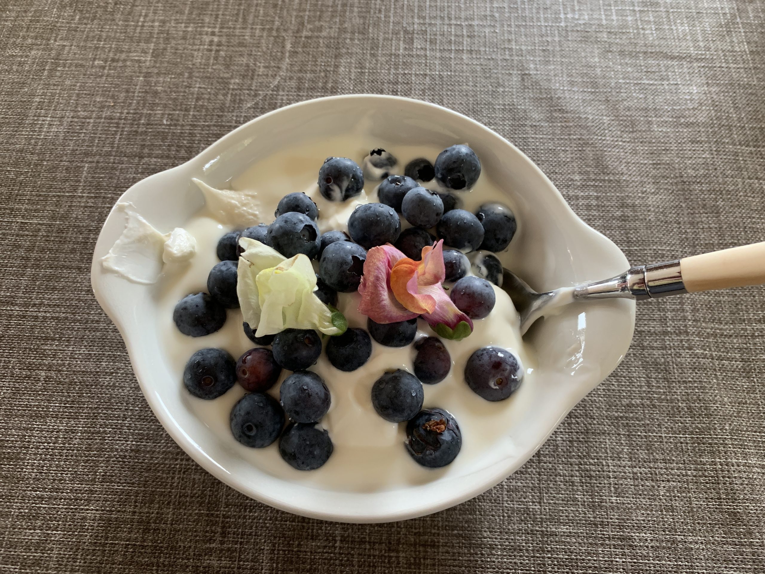 zelfgemaakte yoghurt met bosbessen en eetbare bloemen
